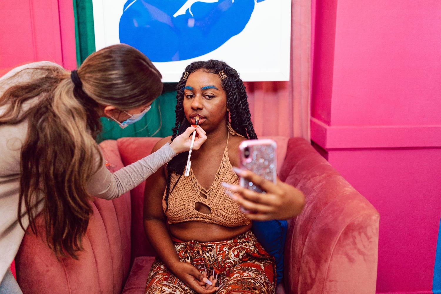 A make-up artist applies cosmetics to a model